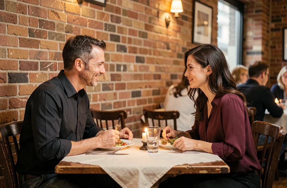 Couple complice échangeant des regards amusés lors d'un dîner romantique au restaurant