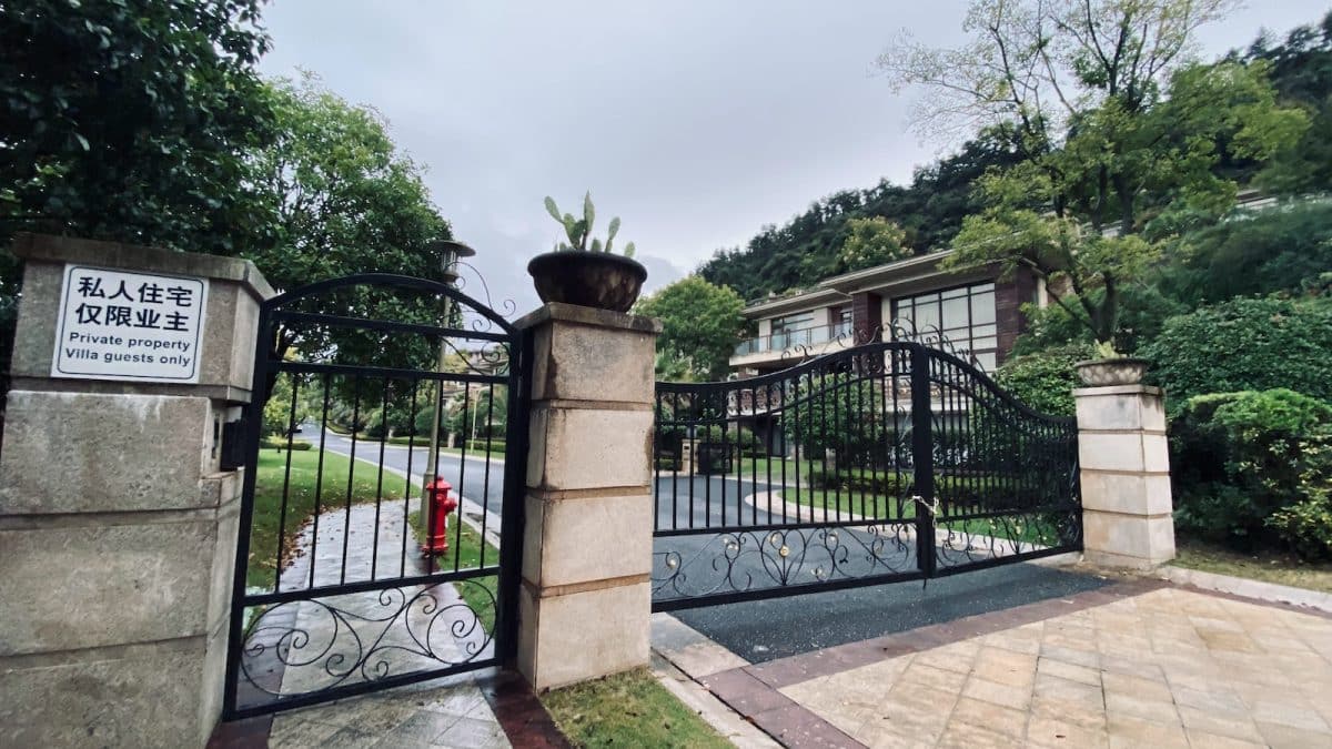 black metal fence near green trees during daytime