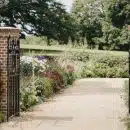 brown wooden gate near green grass and trees during daytime