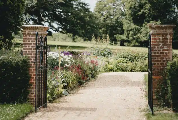 brown wooden gate near green grass and trees during daytime
